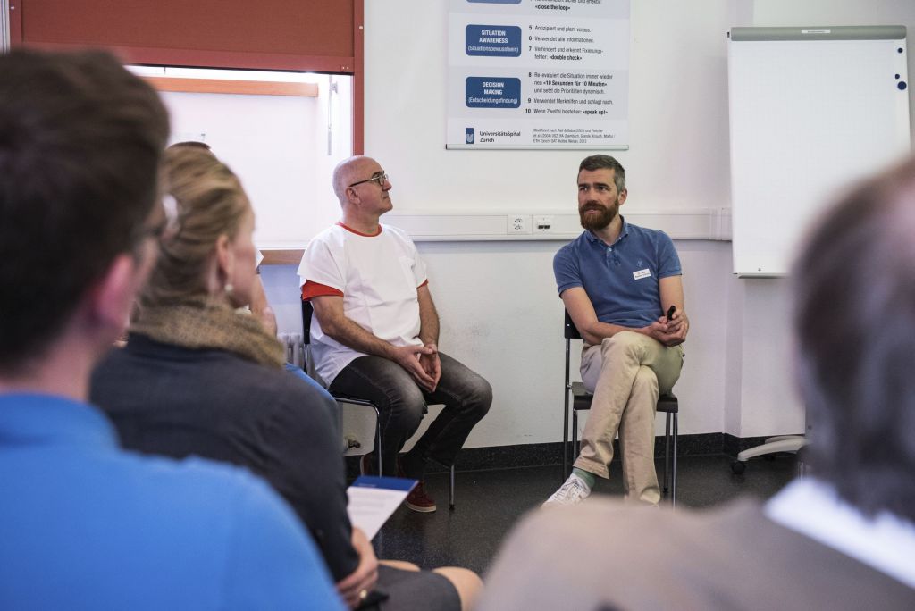 Debriefing Runde mit einem Leiter und mehreren Zuhörern