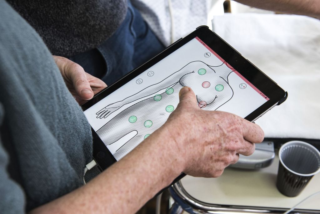 Tablet wird bedient und zeigt verschiedene Punkte bei der Puppe