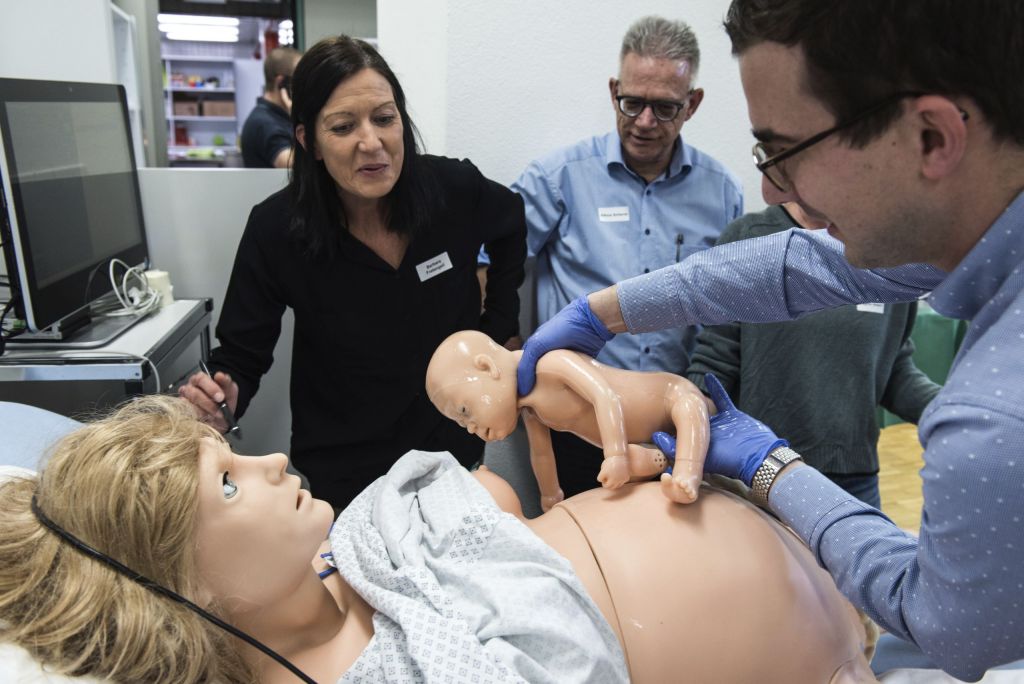 Schwangerschaftssimulation mit Frau und Neugeborenem Puppe