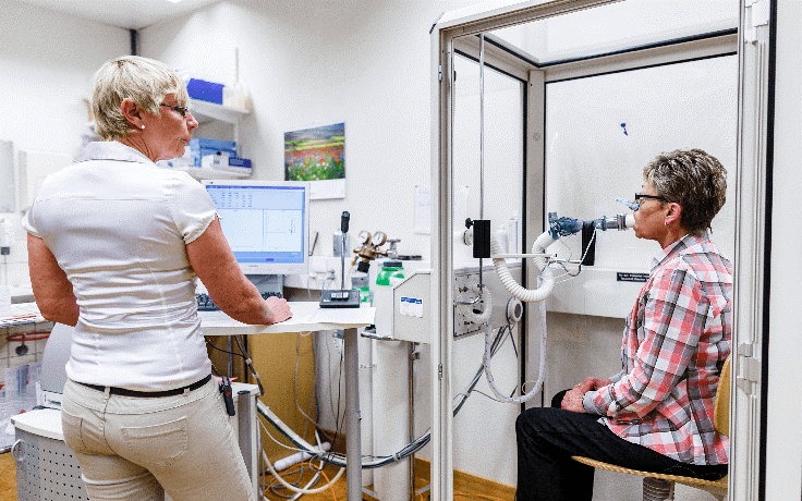 Eine Ärztin führt einen Lungenfunktionstest bei einer Patientin durch