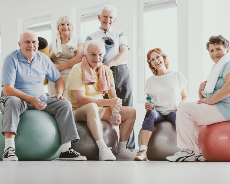 Ältere Personen sitzen auf Gymnastikbällen