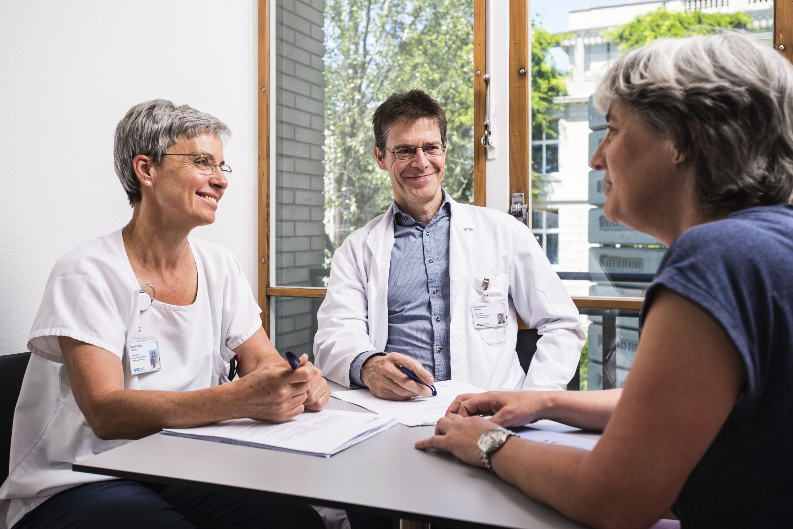 Ein Arzt und eine Pflegeexpertin beraten eine Patientin